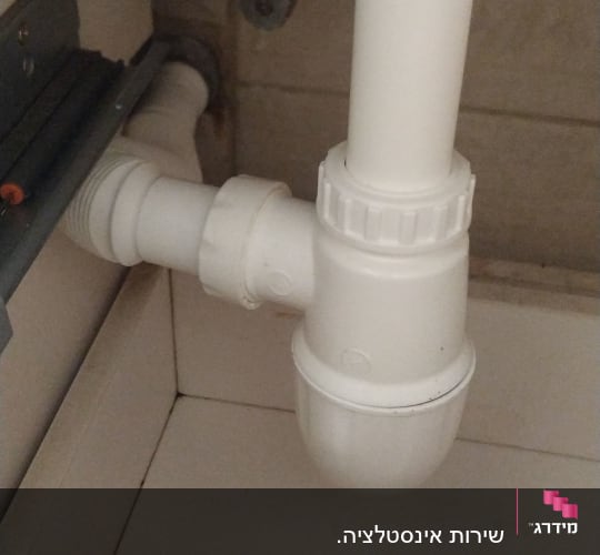 צנרת פלסטיק לבנה מתחת לכיור